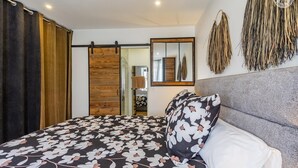 A bedroom with a bed, a sliding door, a mirror, and a wall decoration. - LE REFUGE - DOMESSIN (DOMESSIN)