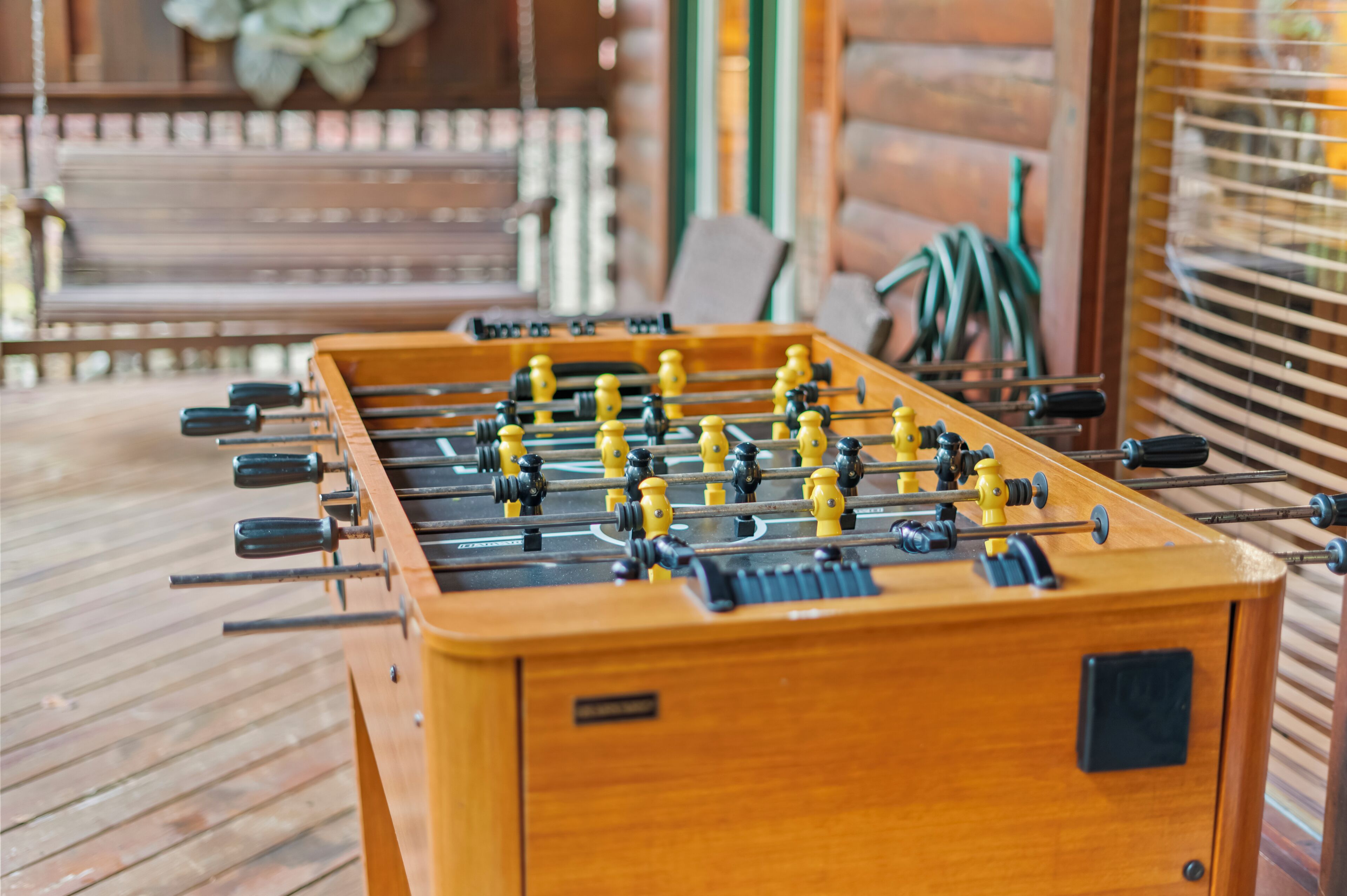 A wooden foosball table on a wooden deck.