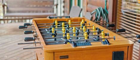 A wooden foosball table on a wooden deck.