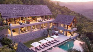 Un resort de varios pisos con asientos al aire libre y una piscina.