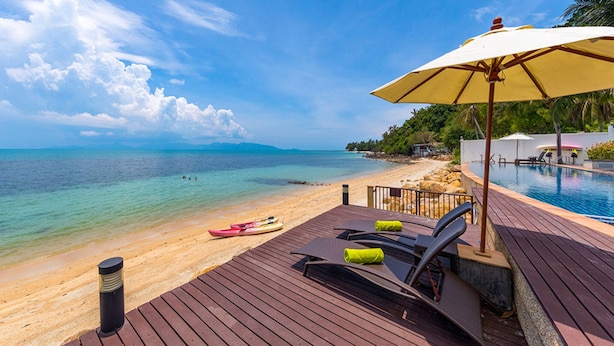 A wooden deck with lounge chairs and a yellow umbrella overlooking a beach with clear turquoise water and a distant mountain range. - Luxury Retreat with Private Chef & Concierge, Koh Samui Villa 1018 (Koh Samui)