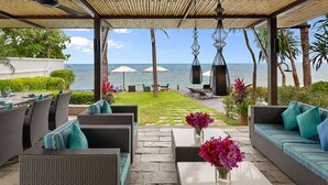 An outdoor patio with wicker furniture, a stone pathway, and a view of the ocean. - Luxury Retreat with Private Chef & Concierge, Koh Samui Villa 1018 (Koh Samui)