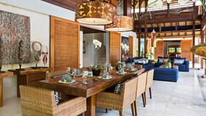A spacious dining area with a long wooden table set for a meal, surrounded by wicker chairs. - Beautiful 5 Star Villa in a Prime Location in Seminyak, Bali Villa 2129 (Bali)