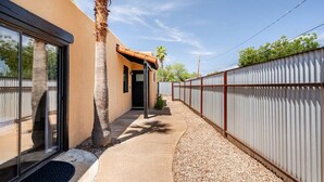A modern house with a covered patio, a palm tree, and a metal fence. - Charming 3-bedroom house in Central location / UofA bike path on Mountain (Tucson)
