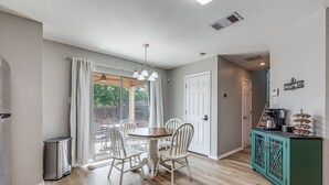 A dining area with a round table and chairs, a green cabinet with a coffee machine, and a door labeled "Coffee Bar". - Bright, fun, and welcoming home near Lackland and Seaworld (San Antonio)