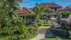 Un resort con varias construcciones, un camino central y abundante vegetación.