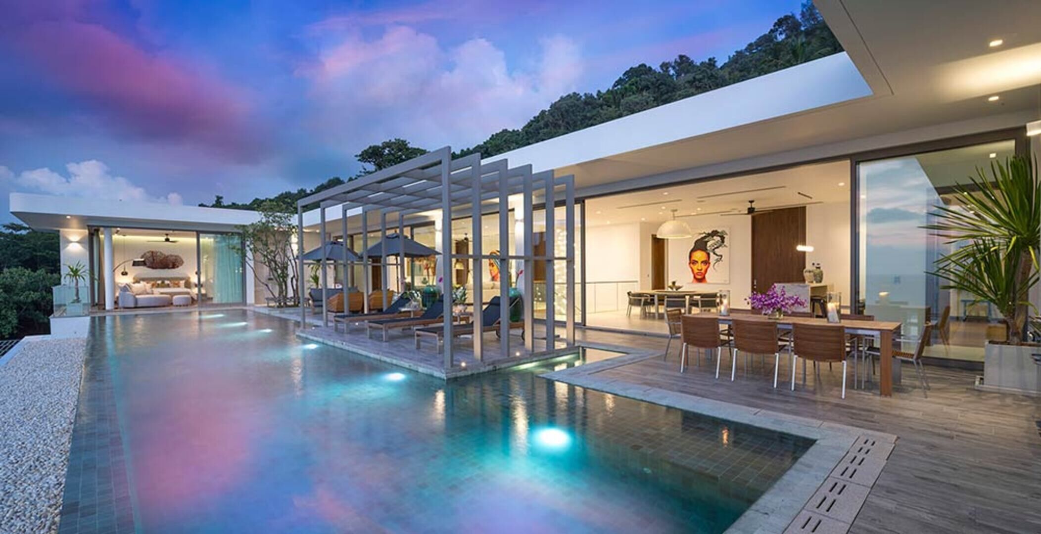 A modern house with a swimming pool, outdoor seating, and a dining area.