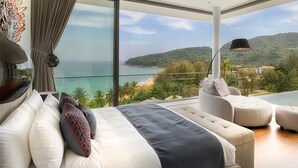A bedroom with a large bed, a sofa, and a view of the sea and hills. - Experience the Ultimate Holiday while staying in this Luxury Villa in Phuket, Phuket Villa 1062 (Phuket)
