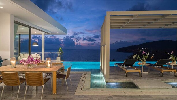 A modern outdoor dining area with a pool, overlooking the sea at dusk. - Experience the Ultimate Holiday while staying in this Luxury Villa in Phuket, Phuket Villa 1062 (Phuket)