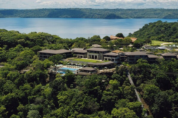 Un resort con varias construcciones, una piscina y vistas a un lago.
