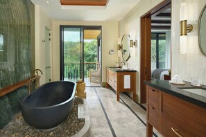 A modern bathroom with a freestanding bathtub, wooden vanity, and a large mirror. - Nekajui Peninsula Papagayo, a Ritz-Carlton Reserve Residence (Papagayo)