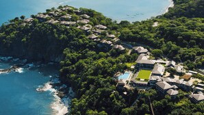 An aerial view of a coastal resort with multiple buildings, a swimming pool, and a beach. - Nekajui Peninsula Papagayo, a Ritz-Carlton Reserve Residence (Papagayo)