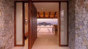 A stone-walled hallway leading to a seating area with a view of mountains. - Nekajui Peninsula Papagayo, a Ritz-Carlton Reserve Residence (Papagayo)