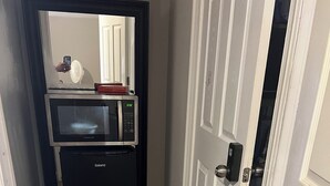 A compact kitchen with a microwave and a refrigerator.
