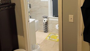 A bathroom with a bathtub, toilet, and sink.