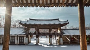 A traditional Korean pavilion with a tiled roof and wooden beams, surrounded by snow. - Anook Hotel Suwon Station (Suwon)