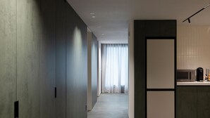 A modern hallway with a kitchen area featuring a microwave and a coffee machine. - Anook Hotel Suwon Station (Suwon)