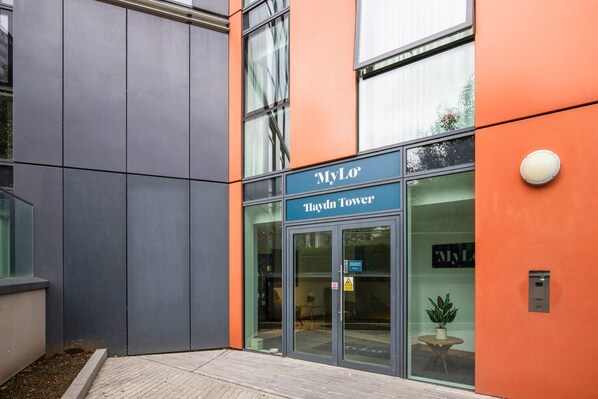 A modern building with a glass entrance, labeled "MyLo Haydn Tower."