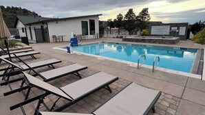 Una piscina con sillas de descanso y una estación de salvavidas.