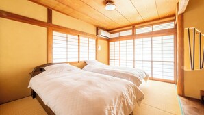 Une pièce de style japonais traditionnel, avec un sol recouvert de tatamis, un plafond en bois et des portes coulissantes en papier de riz (shoji).