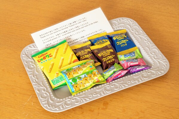 A tray with various packaged snacks and a piece of paper with text.