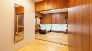 Une pièce avec des boiseries, un canapé blanc et un miroir.