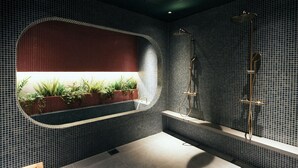 A modern bathroom with a tiled backsplash, a built-in planter with plants, a shower area, and a bench. - TRAN.SCENDER HOTEL Yokohama (Yokohama)