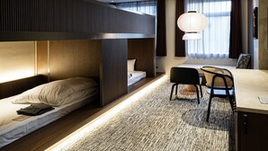A modern hotel room with bunk beds, a desk, chairs, and a large window with curtains. - TRAN.SCENDER HOTEL Yokohama (Yokohama)