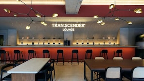 A modern lounge with a bar area, multiple seating arrangements, and a distinctive ceiling design. - TRAN.SCENDER HOTEL Yokohama (Yokohama)