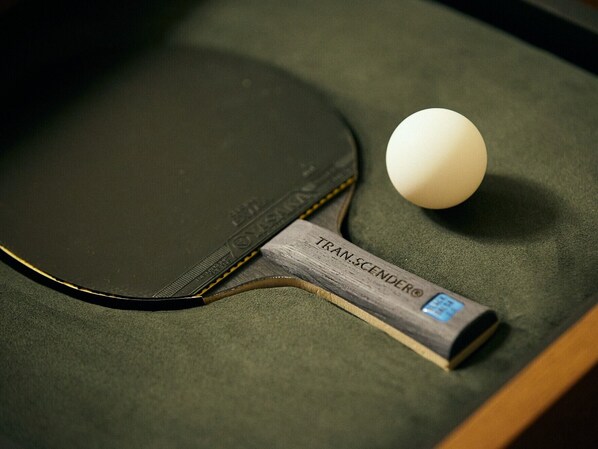 A table with a table tennis paddle and ball.