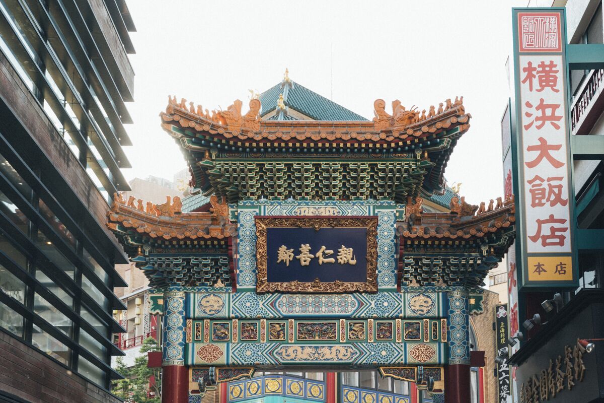 Ein traditionelles chinesisches Tor mit aufwendigen Verzierungen und einem Schild mit der Aufschrift '新春仁祥'.
