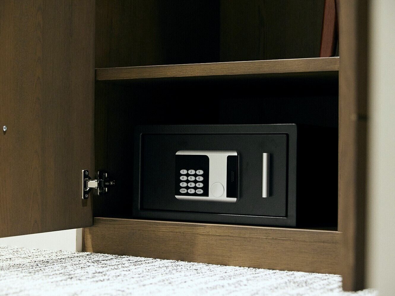 A microwave in a cabinet with a keypad.