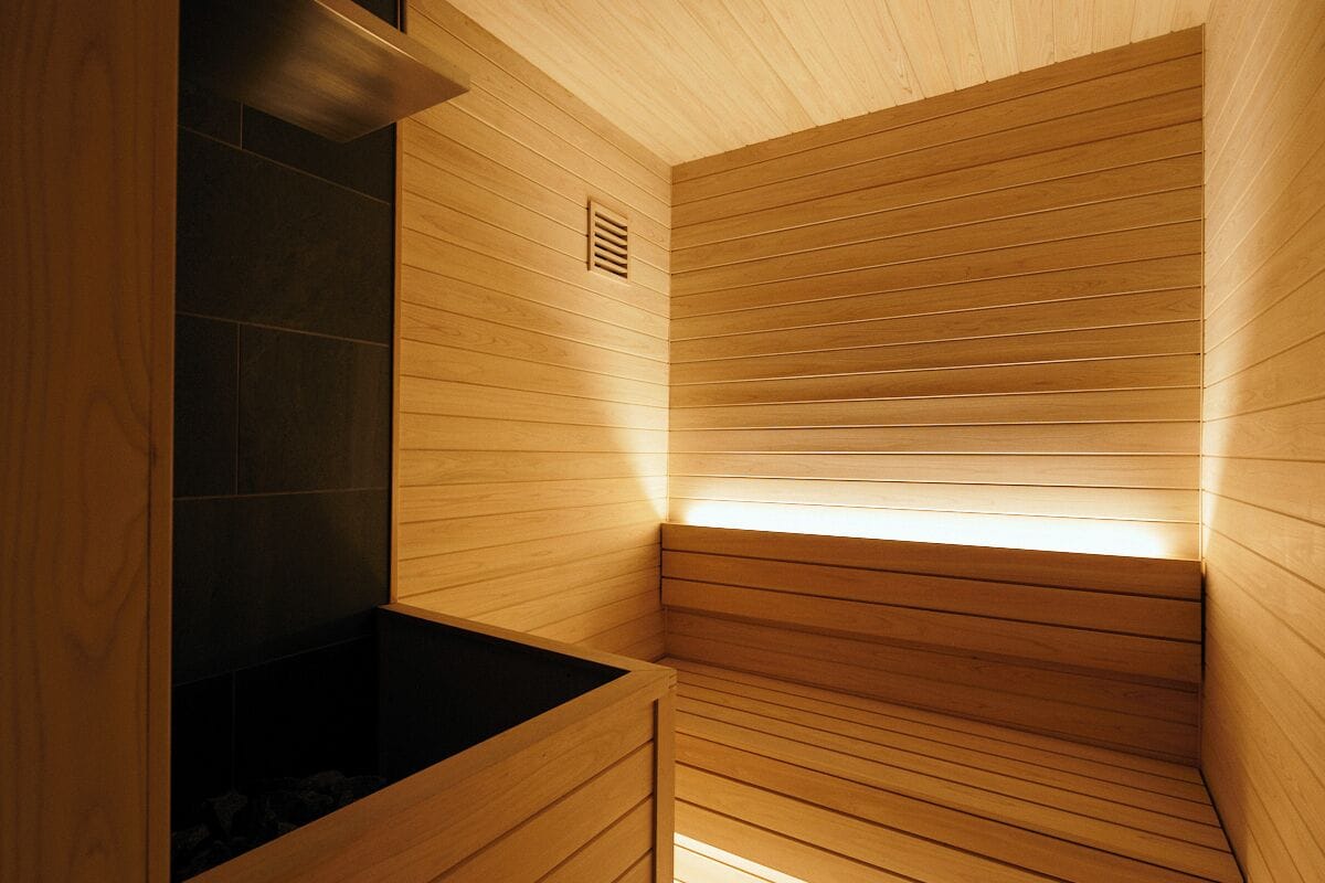Eine Sauna mit Holzwänden und einem schwarzen, beheizten Boden.