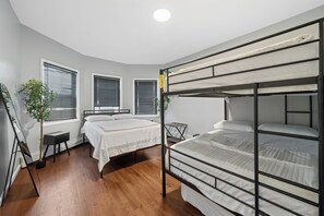 Una habitación con dos literas, una mesita y una planta en maceta.
