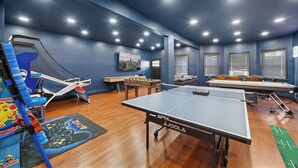 Une pièce équipée d’une table de ping-pong, d’un baby-foot et d’un canapé.