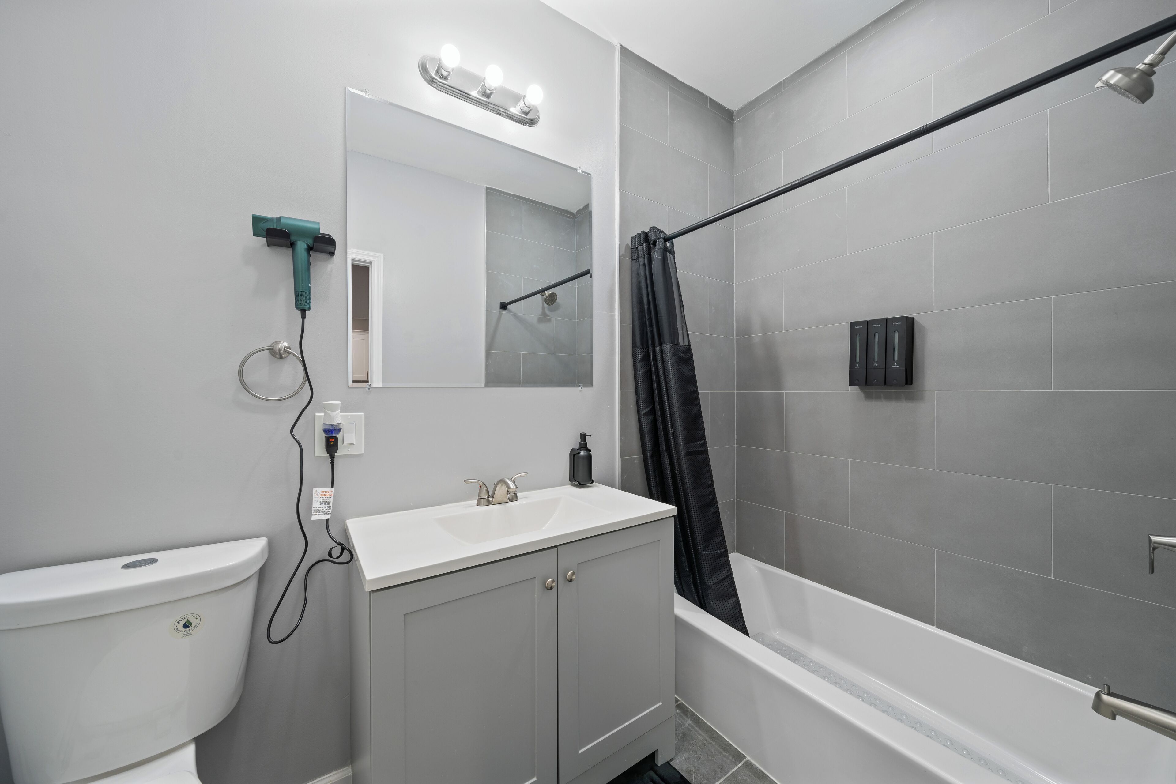 A modern bathroom with a toilet, sink, vanity, and a shower area.