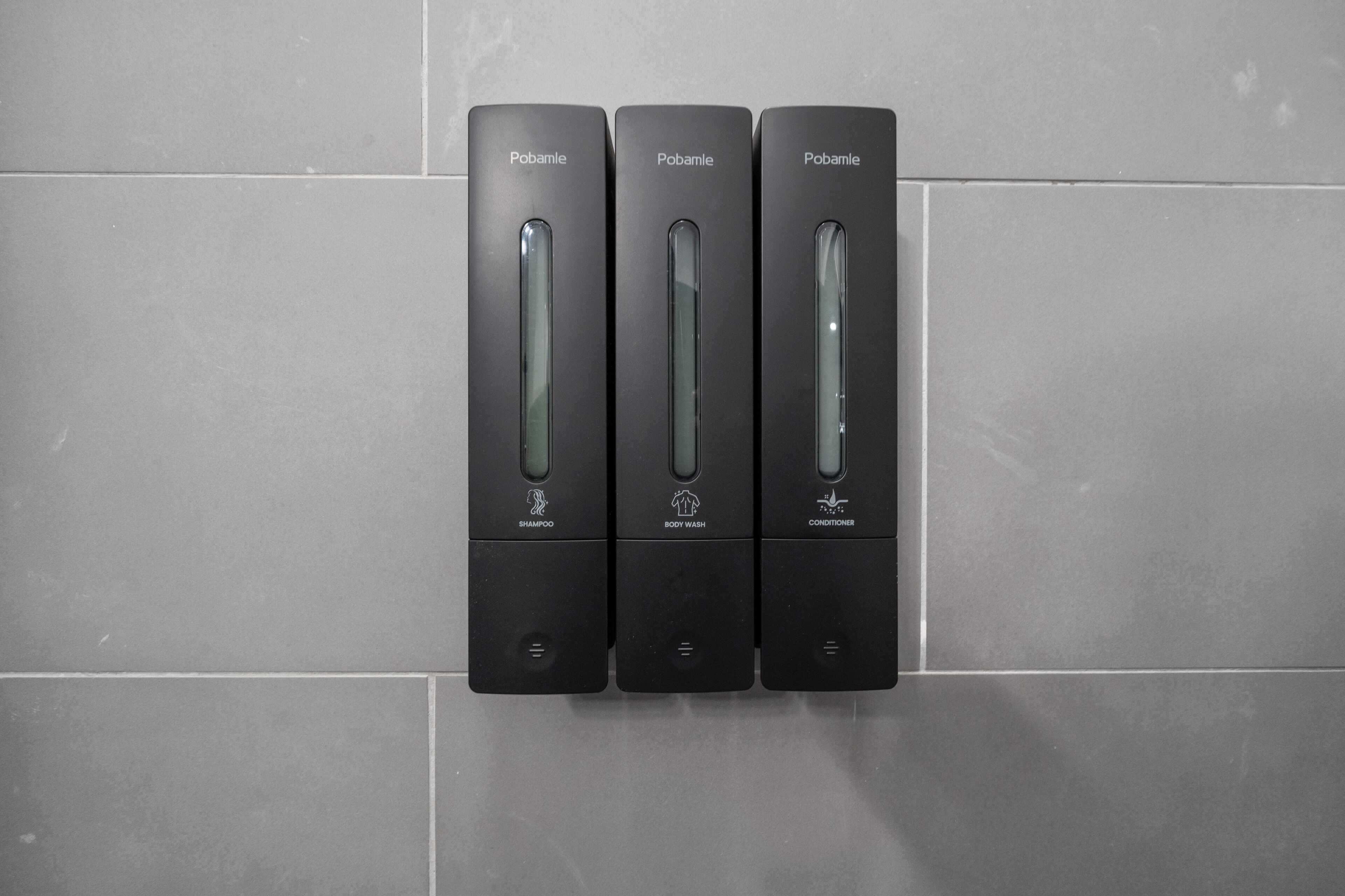 Tres dispensadores negros etiquetados como 