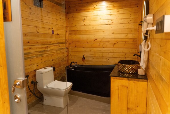 A wooden-paneled bathroom with a toilet, a bathtub, and a sink. - Tranquillo By The Beach - Luxury Wooden (Calangute)