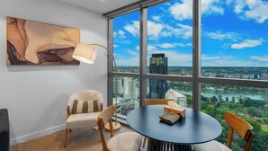 A modern room with a large window, a round table, and a sofa.