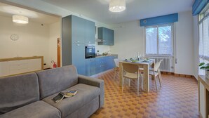 A compact living space with a kitchenette, a dining area, and a sofa. - Diana & Mark family house, Vobarno, Italy (Vobarno)