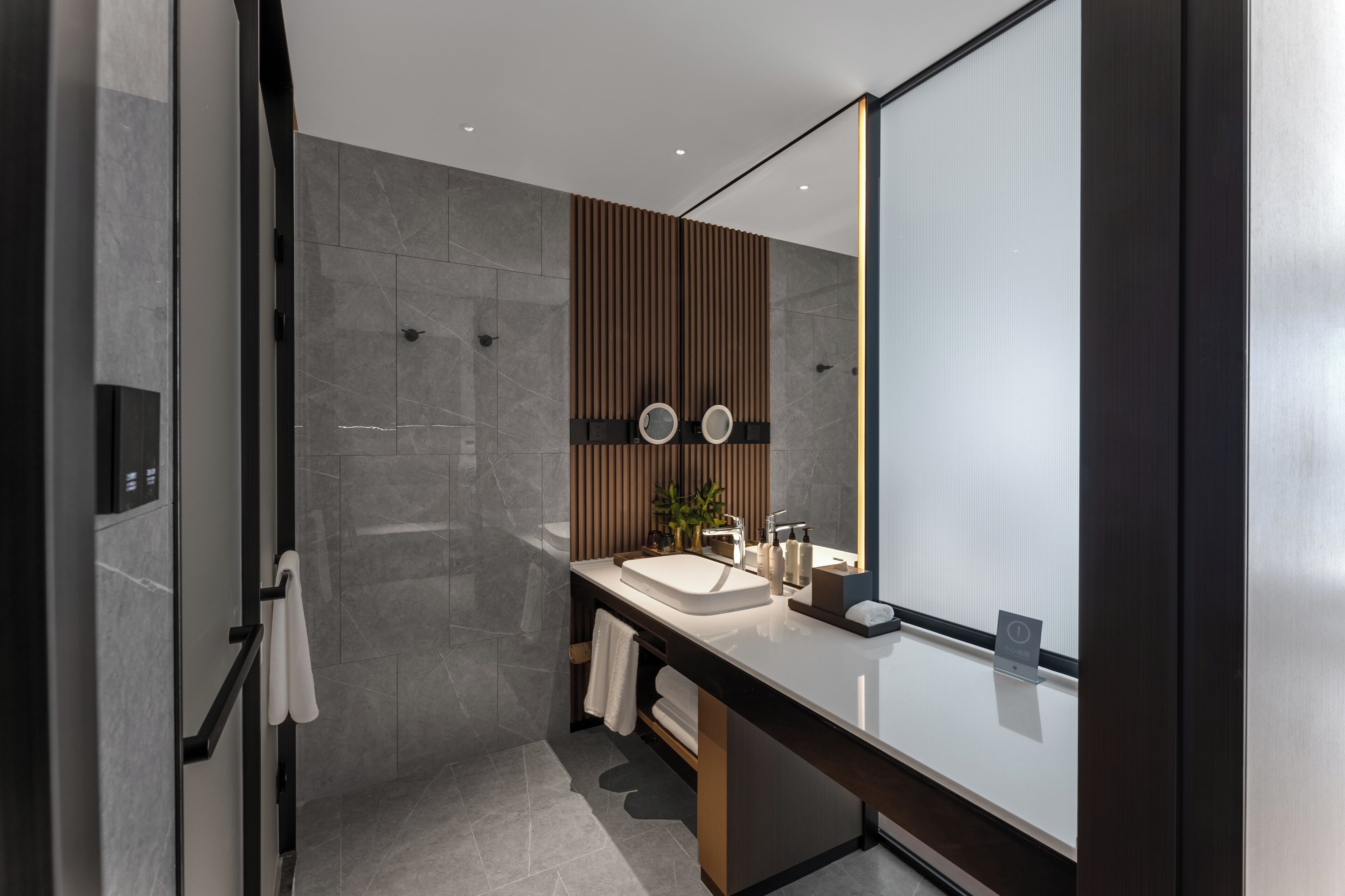 Une salle de bain moderne avec un grand miroir, un lavabo et un porte-serviettes.