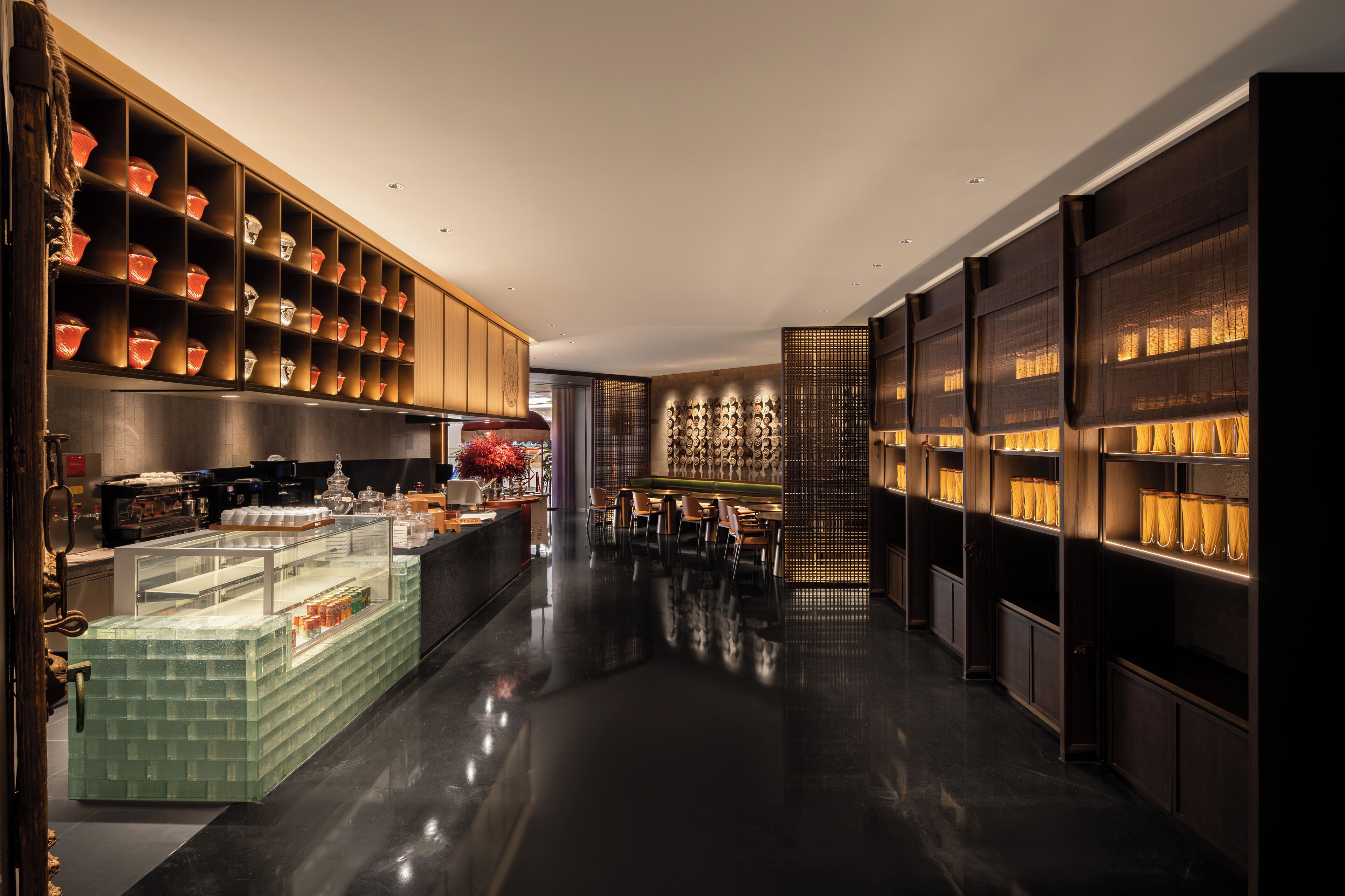 A modern hotel lobby with a central bar area, seating, and decorative elements.