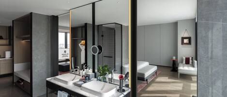 Un baño moderno con lavamanos dobles, un espejo grande y una zona de ducha.