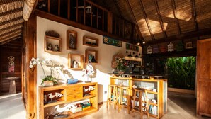 A rustic kitchen with wooden cabinetry, a central island with stools, and various decorative items on the walls.