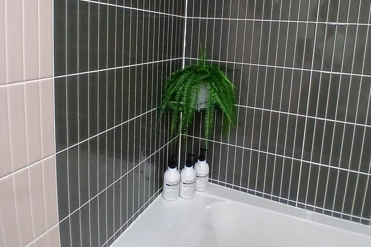 Combined shower/bathtub, hair dryer, slippers, towels