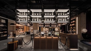 A modern interior with a central bar area, shelves with decorative items, and a polished floor. - Beijing Dongba Wanda Moments hotel (Beijing)