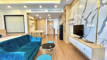 Habitación cuádruple Deluxe, balcón, vista al mar | Área de sala de estar | Smart TV de 55 pulgadas con canales digitales