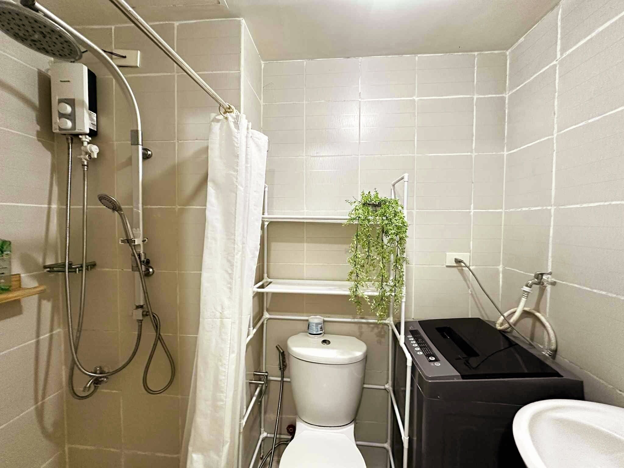 A small, compact bathroom with a shower, toilet, and sink.