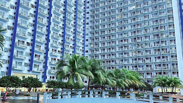 A high-rise residential building with a pool area in the foreground. - Fourth's Jazz Cozy Pad (Makati)