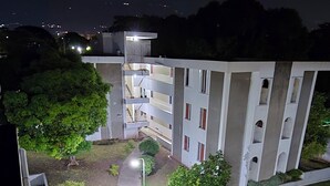 A multi-story building with a central staircase, surrounded by well-maintained greenery and a paved pathway. - The Central Comfort in Kingston (Kingston)